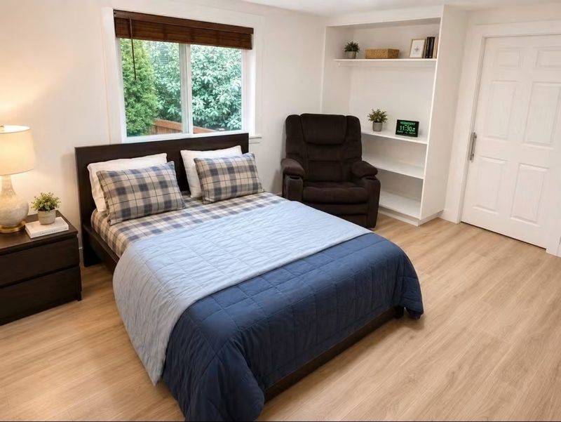 Private bedroom with bed, armchair, window and shelving