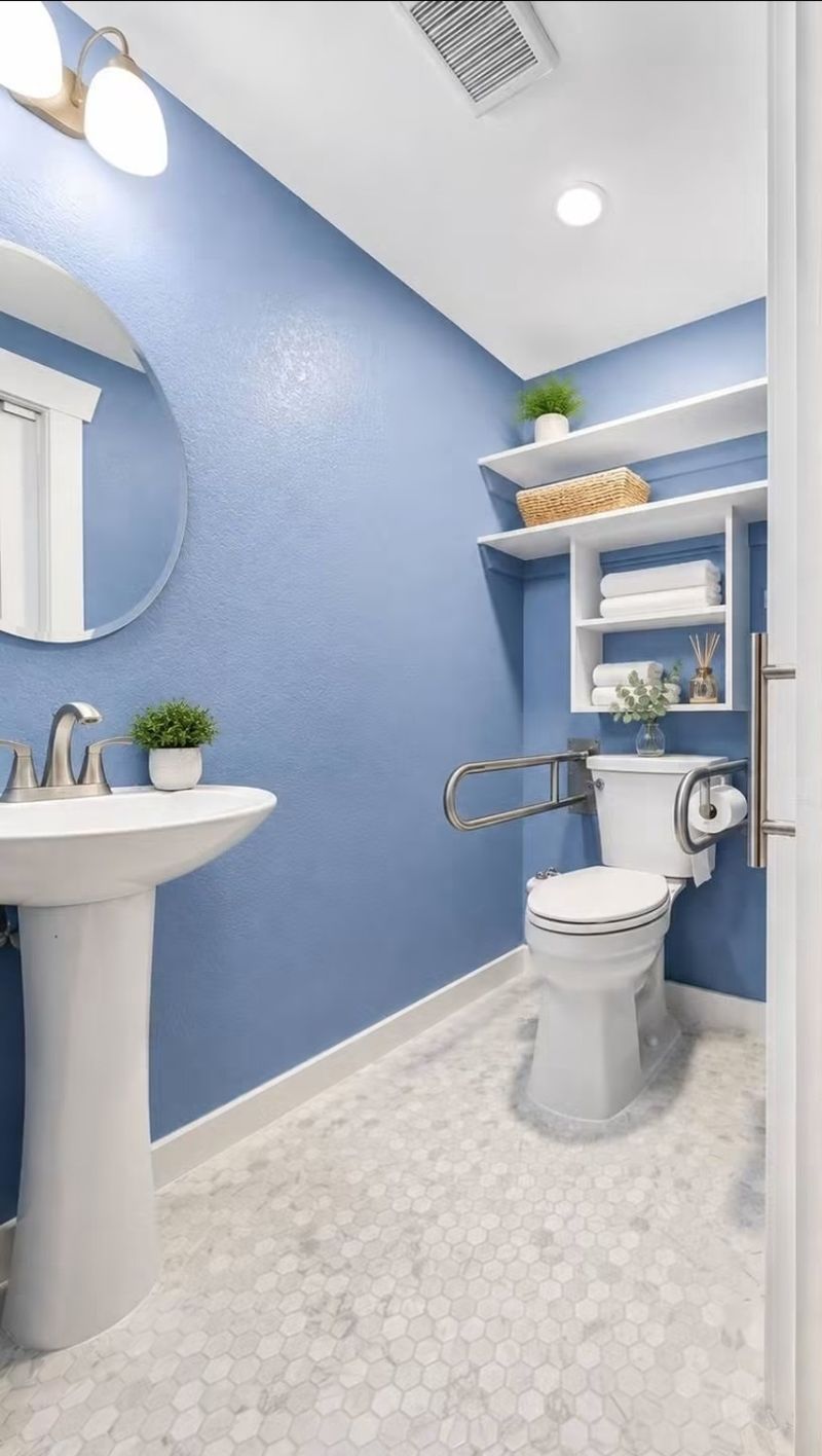Private half bathroom with sink, toilet and support rails